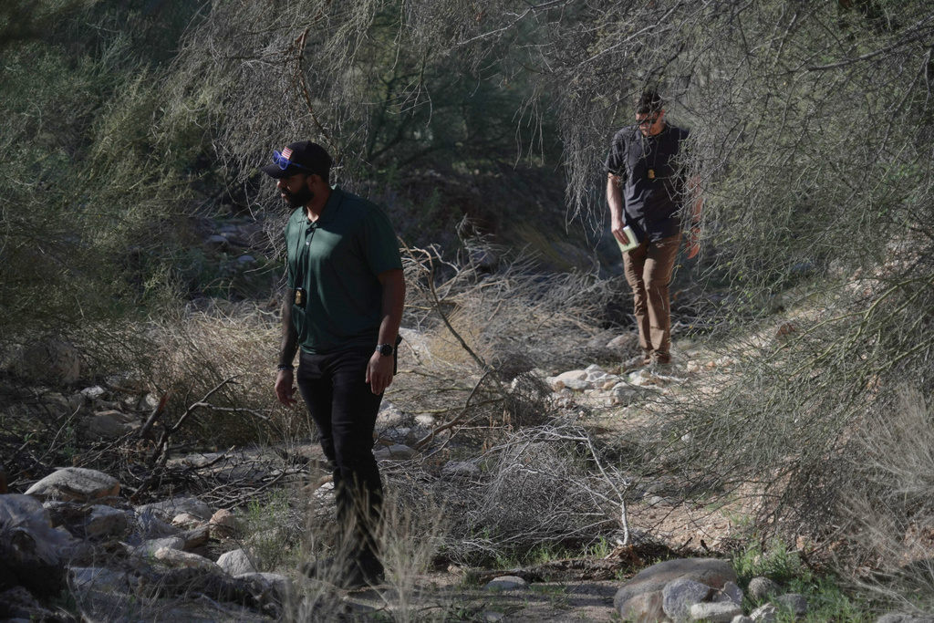 Law enforcement agents check vegetation areas around Nancy Guthrie’s home in Tucson, Ariz., Wednesday, Feb. 11, 2026. (AP Photo/Ty ONeil)