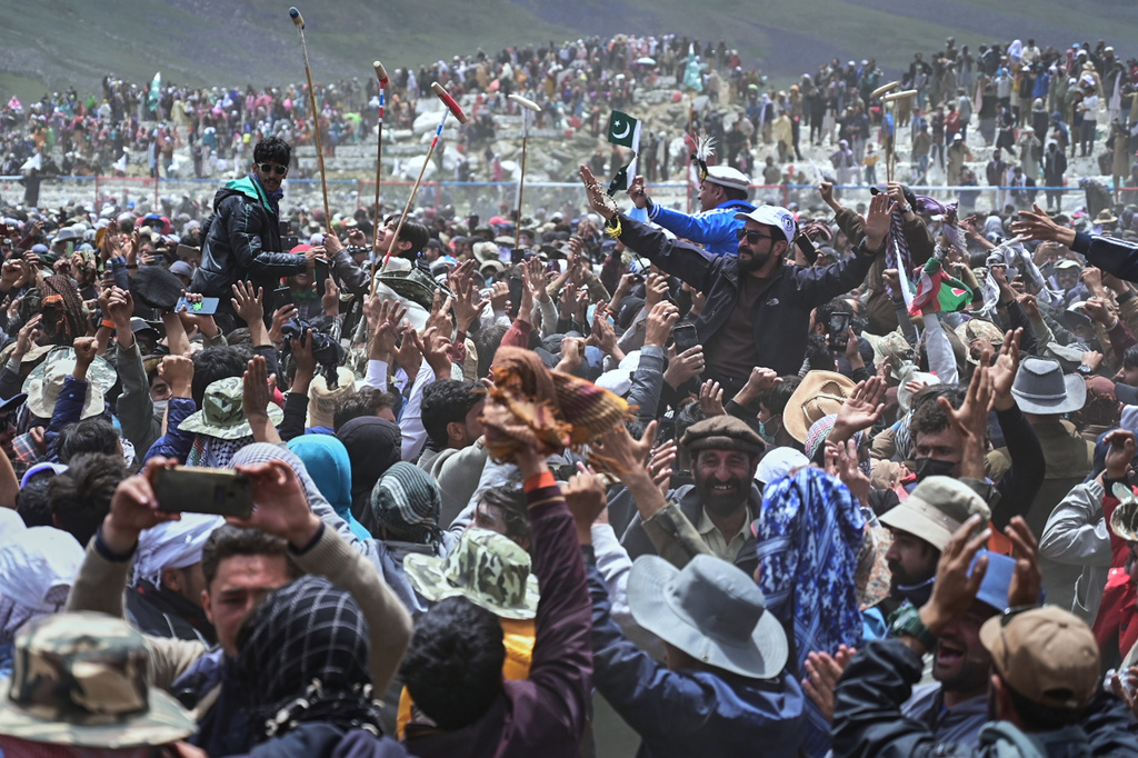 Players of Gilgit-Baltistan region team and their supporters celebrate after their team won the final polo match against Chitral region team during the three-day annual Shandur Polo Festival in Shandur Pass, in the Ghizer district of Gilgit-Baltistan, northern Pakistan, Saturday, June 13, 2026. (AP Photo/Zubair Abbasi)