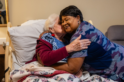 Shirley Warthen, 93, a resident, left, pulls in Jackie Conteh, an advanced care partner originally from Sierra Leone, for a hug in her apartment at Goodwin House Alexandria, Thursday, Oct. 16, 2025, in Alexandria, Va. (AP Photo/Eric Lee) Shirley Warthen, 93, a resident, left, pulls in Jackie Conteh, an advanced care partner originally from Sierra Leone, for a hug in her apartment at Goodwin House Alexandria, Thursday, Oct. 16, 2025, in Alexandria, Va. (AP Photo/Eric Lee)