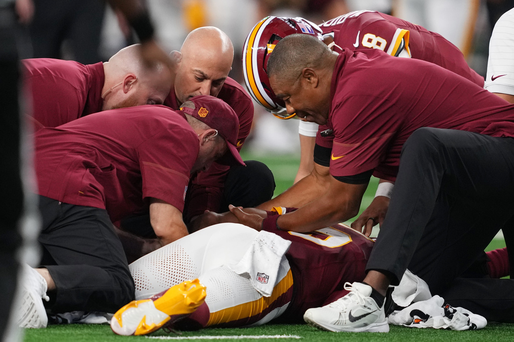 Trainers attend to Washington Commanders quarterback Jayden Daniels (5) after an apparent injury in the first half against the Dallas Cowboys during an NFL football game in Arlington, Texas, Sunday, Sept. 20, 2026. (AP Photo/Tony Gutierrez)
