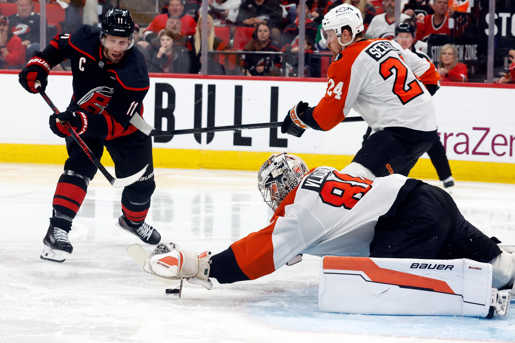 Carolina Hurricanes' Jordan Staal (11) lunges for the puck with Philadelphia Flyers goaltender Dan Vladar (80) and Nick Seeler (24) nearby during the second period of Game 1 of an NHL hockey Stanley Cup second-round playoff series in Raleigh, N.C., Saturday, May 2, 2026. (AP Photo/Karl DeBlaker)