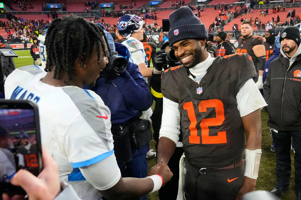 Tennessee Titans quarterback Cam Ward, left, and Cleveland Browns quarterback Shedeur Sanders (12) greet each other after an NFL football game in Cleveland, Sunday, Dec. 7, 2025. (AP Photo/Sue Ogrocki)