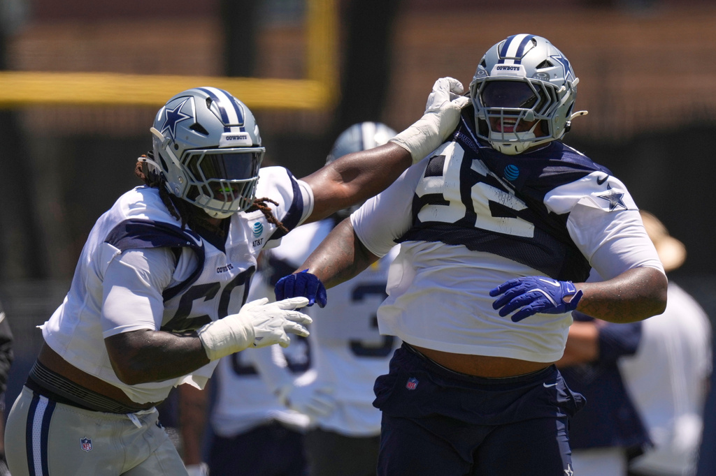 Dallas Cowboys offensive tackle Tyler Guyton, left, holds defensive tackle Quinnen Williams back during the NFL football team's training camp, Saturday, Aug. 1, 2026, in Oxnard, Calif. (AP Photo/Mark J. Terrill)