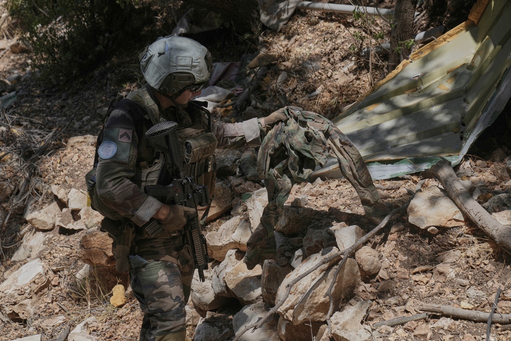 A French U.N. peacekeeper inspects a destroyed Hezbollah position in the Saluki Valley, south Lebanon, Wednesday, Aug. 20, 2025. (AP Photo/Hussein Malla)"