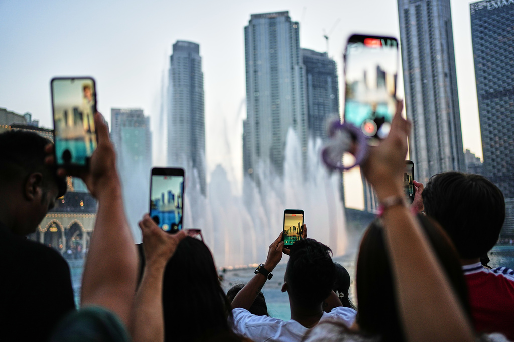 People photograph the Dubai Fountain with skyscrapers in the background outside Dubai Mall on the first day of the Eid al-Adha holiday in Dubai, United Arab Emirates, Wednesday, May 27, 2026. (AP Photo/Fatima Shbair)