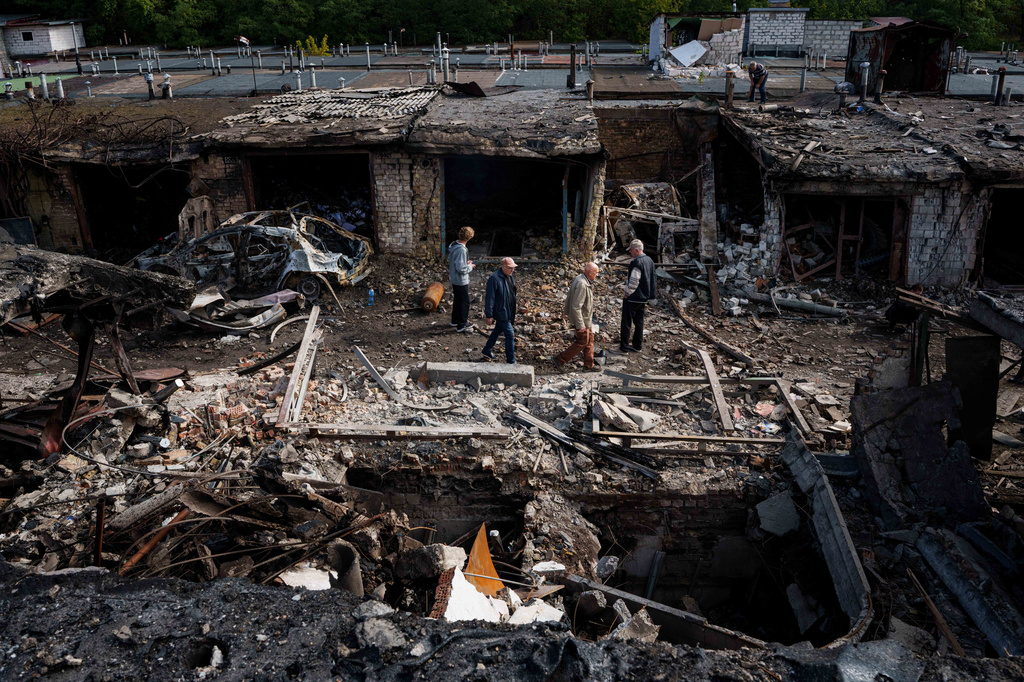 People walk in front of garages destroyed in a Russian missile strike on Vyshhorod, Kyiv region, Ukraine, Wednesday, Sept. 30, 2026. (AP Photo/Evgeniy Maloletka)