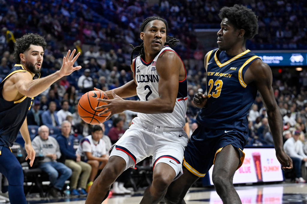 UConn guard Silas Demary Jr., center, drives to the basket between the defense of New Haven guards Stefano Faloppa, left, and Najimi George, right, during the first half of an NCAA college basketball game, Monday, Nov. 3, 2025, in Storrs, Conn. (AP Photo/Jessica Hill)