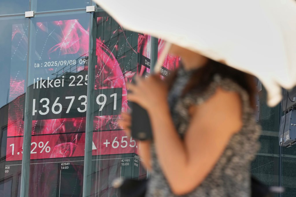 A person walks in front of an electronic stock board showing Japan's Nikkei index at a securities firm Monday, Sept. 8, 2025, in Tokyo. (AP Photo/Eugene Hoshiko)