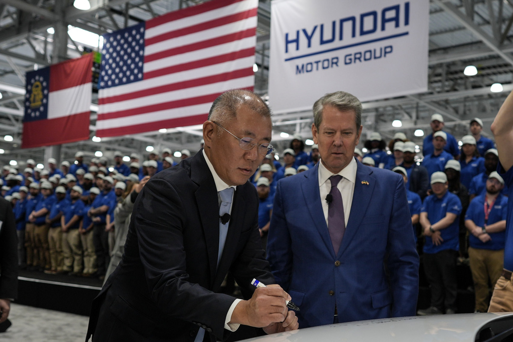 FILE - Euisun Chung, Executive Chair, Hyundai Motor Company, left, stands with Georgia Gov. Brian Kemp as Chung signs an IONIQ 9 EV vehicle during a media tour and grand opening at the Hyundai Motor Group Metaplant America, March 26, 2025, in Ellabell, Ga. (AP Photo/Mike Stewart)