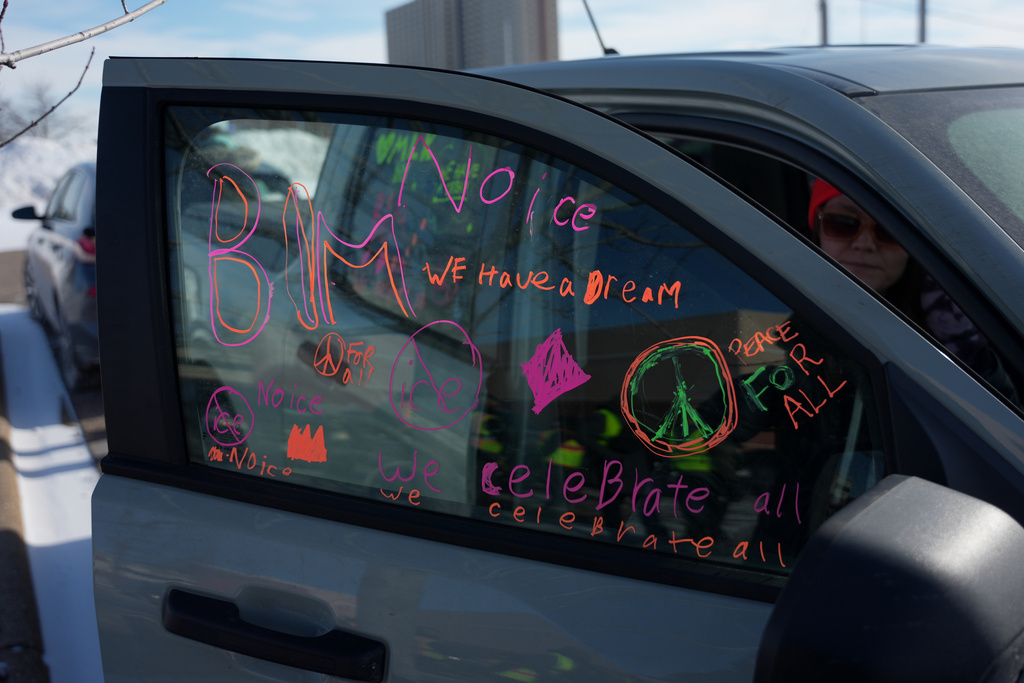 A protester writes pro BLM and Anti-ICE rhetoric on the window of her car during an ICE protest and celebration of MLK day, Monday, Jan. 19, 2026 in St. Paul, Minn. (AP Photo/Angelina Katsanis)