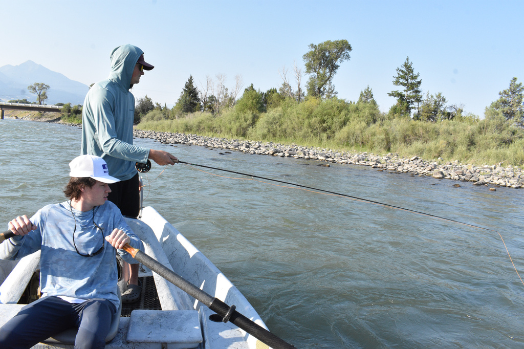Marek Senn fishes for trout while Jase Joslin rows their boat down the Yellowstone River, Friday, July 31, 2026, near Livingston, Montana.(AP Photo/Matthew Brown)