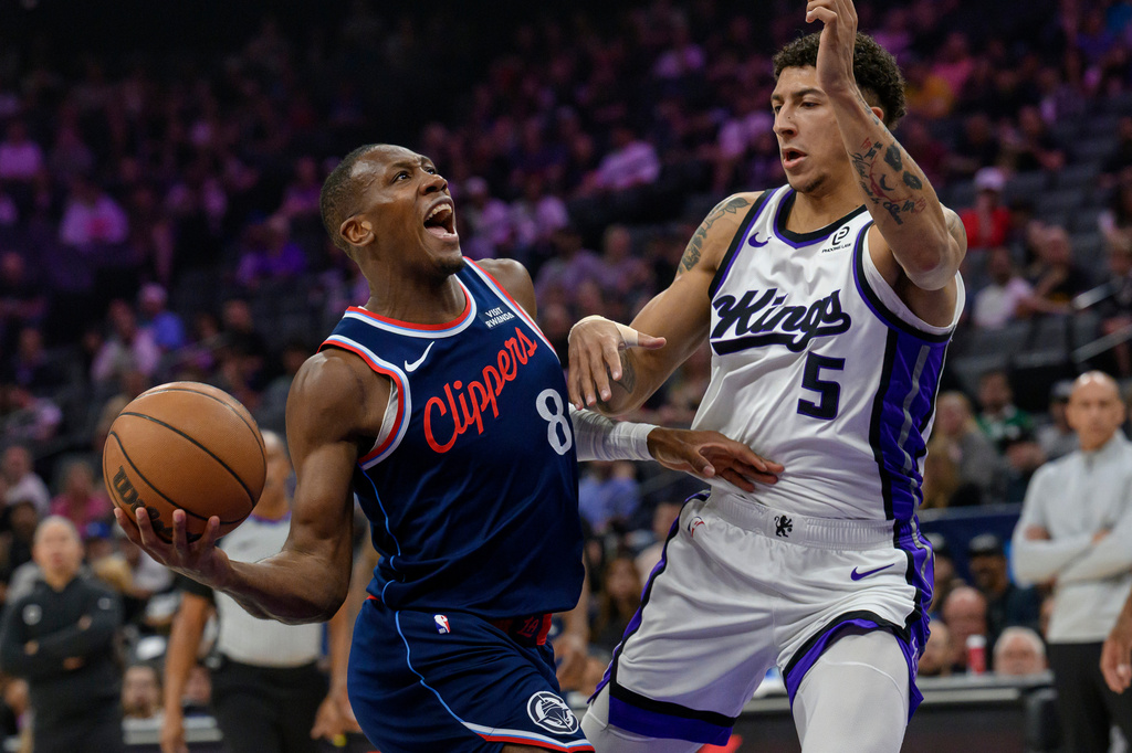 Los Angeles Clippers guard Kris Dunn (8) drives past Sacramento Kings guard Nique Clifford (5) during the first half of an NBA basketball game in Sacramento, Calif., Sunday, April 5, 2026. (AP Photo/Randall Benton)