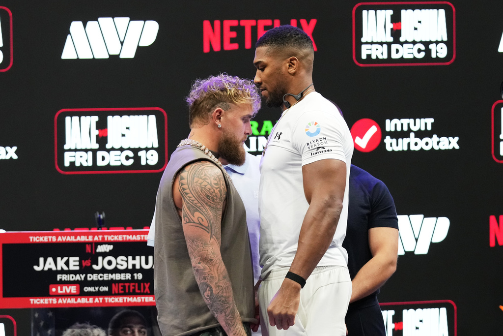 Jake Paul, left, and Anthony Joshua, right, face off during a news conference, Friday, Nov. 21, 2025, in Miami, promoting their upcoming heavyweight boxing match. (AP Photo/Lynne Sladky)