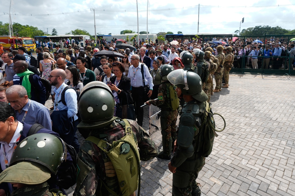 Attendees wait to get into the venue for the COP30 U.N. Climate Summit after an entrance that was closed during a demonstration has been reopened, Friday, Nov. 14, 2025, in Belem, Brazil. (AP Photo/Fernando Llano)