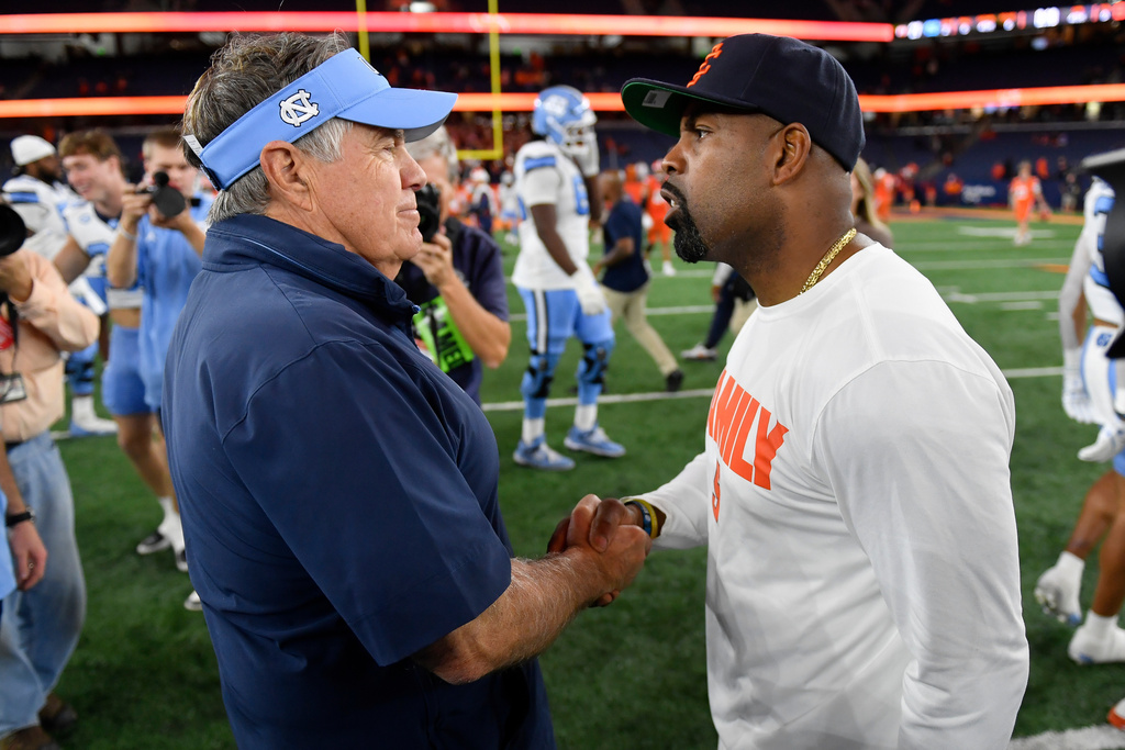 North Carolina head coach Bill Belichick, left, and Syracuse head coach Fran Brown, right, shake hands after an NCAA college football game Friday, Oct. 31, 2025, in Syracuse, N.Y. (AP Photo/Adrian Kraus)