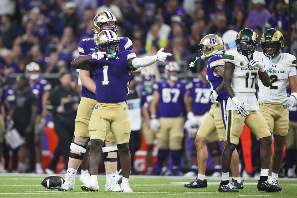 Washington running back Jonah Coleman (1) reacts after a run as Colorado State defensive back CJ Blocker (17) looks on during the first half of an NCAA college football game Saturday, Aug. 30, 2025, in Seattle. (AP Photo/Lindsey Wasson)