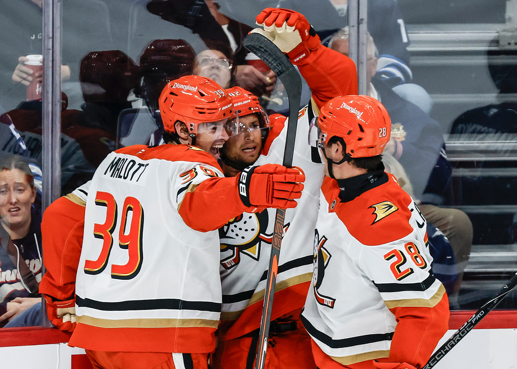 Anaheim Ducks' Jeff Malott (39), Tim Washe (42) and Judd Caulfield (28) celebrate after Washe's goal against the Winnipeg Jets during the second period of an NHL hockey game in Winnipeg, Manitoba, Friday, Oct. 9, 2026. (John Woods/The Canadian Press via AP)