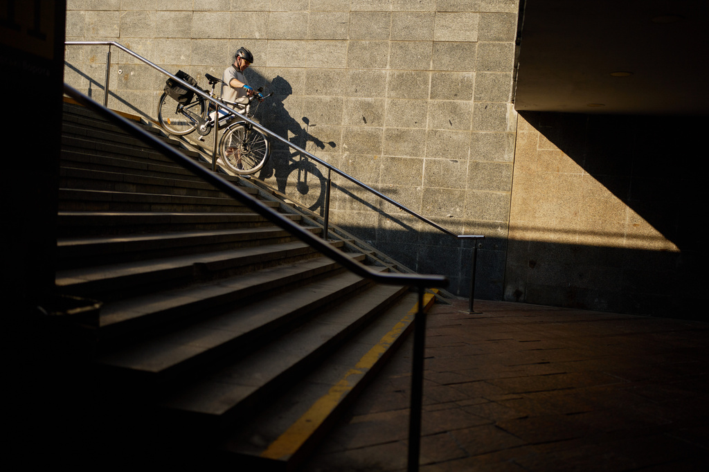 A man carries his bicycle down stairs in a passage under Independence Square in central Kyiv, Ukraine, on Saturday, Aug. 22, 2026. (AP Photo/Francisco Seco)