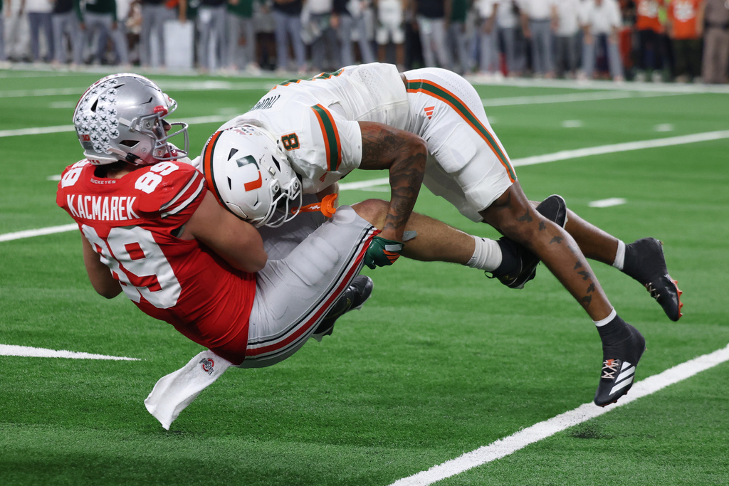 Miami defensive back Jakobe Thomas, right, makes a tackle on Ohio State tight end Will Kacmarek during the second half of the Cotton Bowl College Football Playoff quarterfinal game Wednesday, Dec. 31, 2025, in Arlington, Texas. (AP Photo/Gareth Patterson)