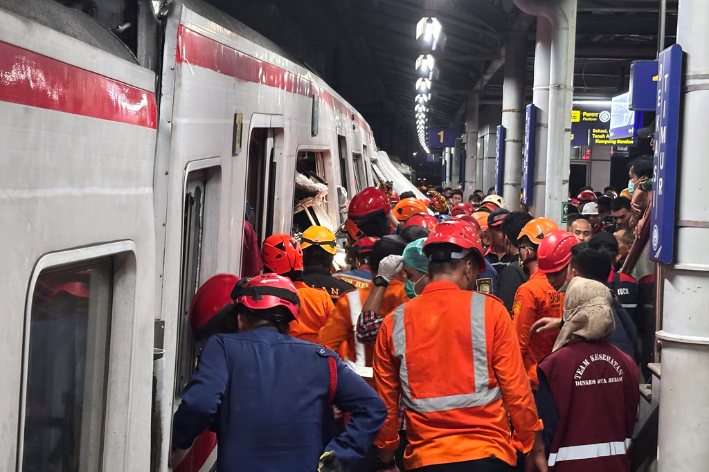 Rescuers search for victims after a train collision at a station in Bekasi, Indonesia, Monday, April 27, 2026. (AP Photo/Achmad Ibrahim)