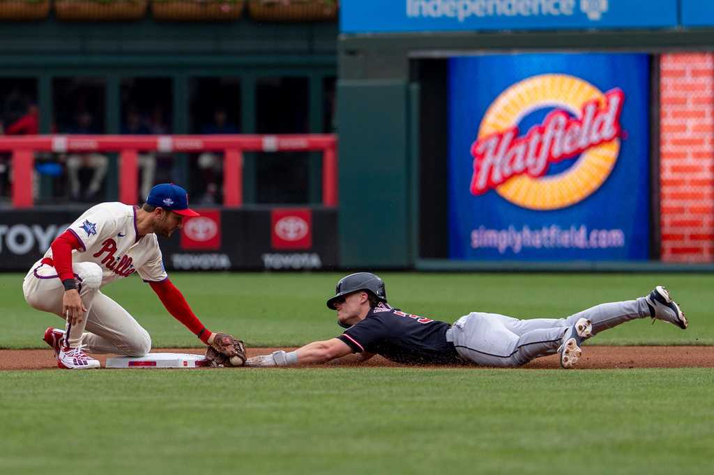 Philadelphia Phillies shortstop Trea Turner, left, tags Cleveland Guardians' Travis Bazzana, right, out as he tries to steal second base during the first inning of a baseball game, Sunday, May 24, 2026, in Philadelphia. (AP Photo/Chris Szagola)