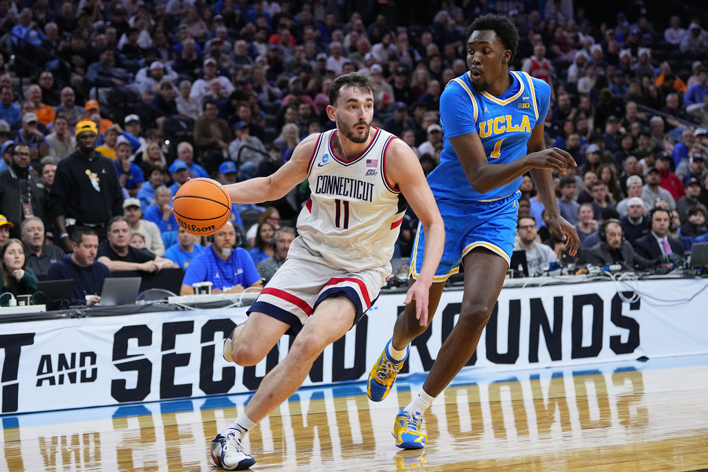 UConn's Alex Karaban (11) tries to get past UCLA's Xavier Booker during the first half in the second round of the NCAA college basketball tournament, Sunday, March 22, 2026, in Philadelphia. (AP Photo/Matt Rourke)