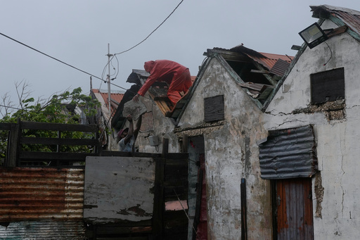 Men remove a loose section of roof in Kingston, Jamaica, as Hurricane Melissa approaches, Tuesday, Oct. 28, 2025. (AP Photo/Matias Delacroix) Men remove a loose section of roof in Kingston, Jamaica, as Hurricane Melissa approaches, Tuesday, Oct. 28, 2025. (AP Photo/Matias Delacroix)