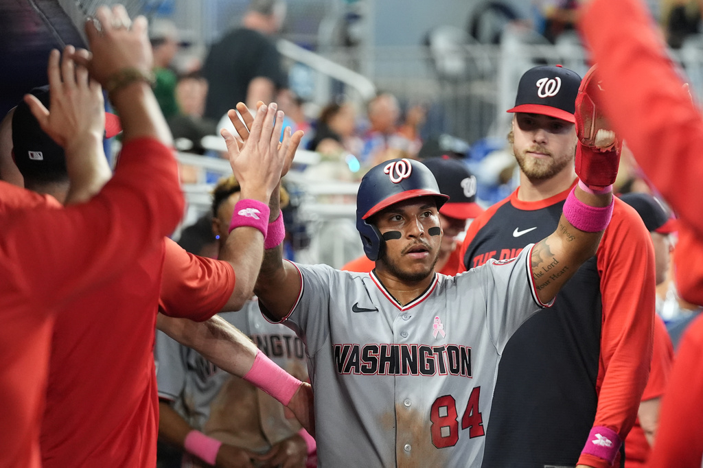 Washington Nationals' Jorbit Vivas (84) is congratulated in the dugout after scoring on a double hit by Luis García Jr. during the fifth inning of a baseball game against the Miami Marlins, Sunday, May 10, 2026, in Miami. (AP Photo/Lynne Sladky)