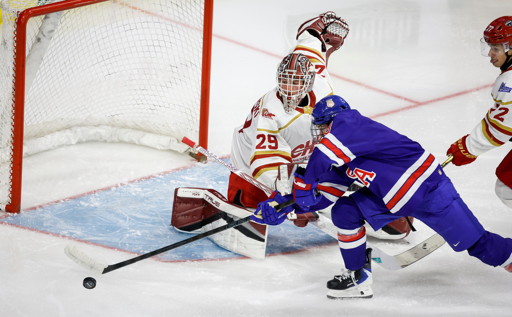 Team USA's Dayne Beuker, right, tries to get the puck past Team CHL goalie Zachary Jovanovski during overtime CHL-USA Prospects Challenge hockey action in Lethbridge, Alberta, on Wednesday, Nov. 26, 2025. (Jeff McIntosh/The Canadian Press via AP)