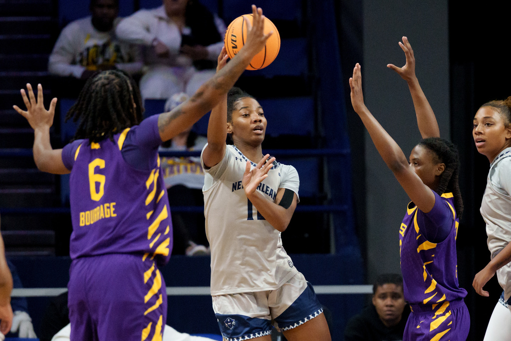 New Orleans guard Lauren Banks, center, passes against LSU guards Divine Bourrage (6) and MiLaysia Fulwiley, second from right, during the first half of an NCAA college basketball game Sunday, Dec. 7, 2025, in New Orleans. (AP Photo/Matthew Hinton)