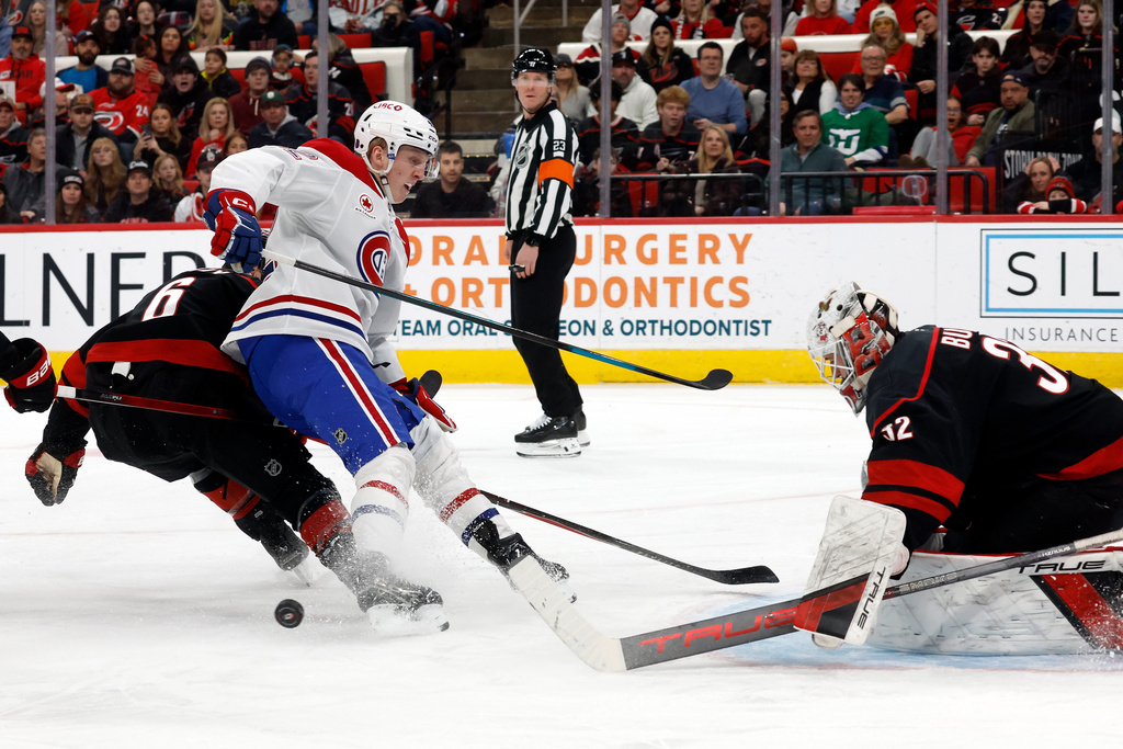 Montréal Canadiens' Adam Engstrom (42) looses control of the puck when approaching Carolina Hurricanes goaltender Brandon Bussi (32) during the first period of an NHL hockey game in Raleigh, N.C., Thursday, Jan. 1, 2026. (AP Photo/Karl DeBlaker)