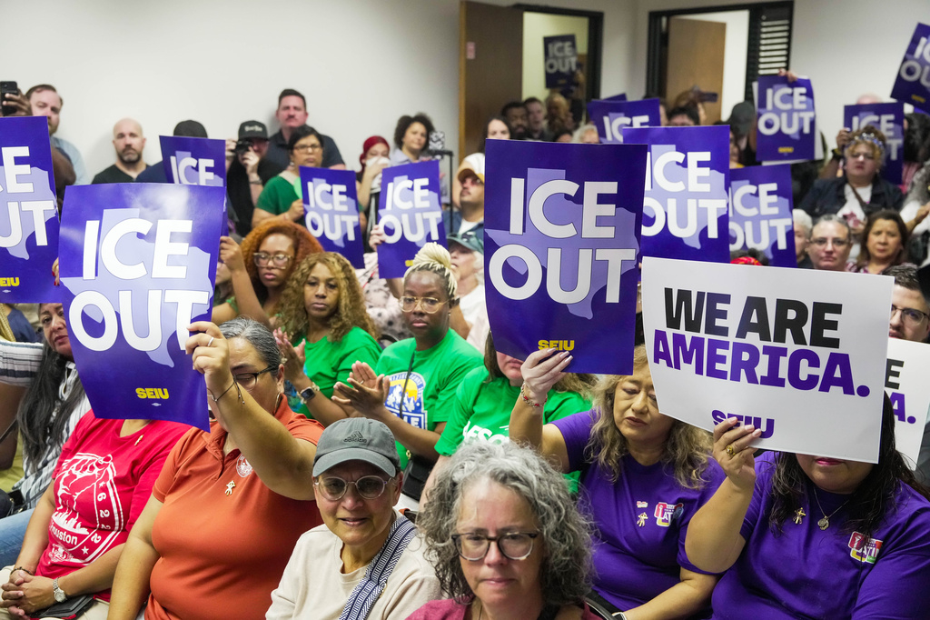 Community members hold signs reading "ICE Out" during a community vigil for Lorenzo Salgado Araujo in Houston on Saturday, July 11, 2026. (Raquel Natalicchio/Houston Chronicle via AP)