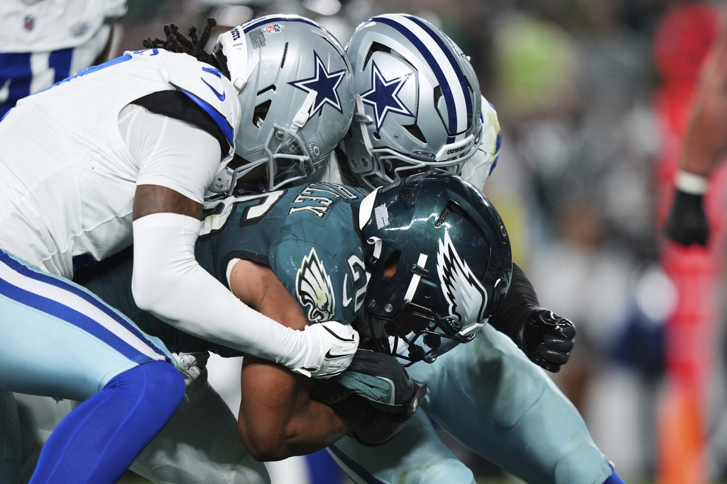 Philadelphia Eagles running back Saquon Barkley gets past Dallas Cowboys defenders as Barkley scores a touchdown in the first half of an NFL football game Thursday, Sept. 4, 2025, in Philadelphia. (AP Photo/Matt Slocum)
