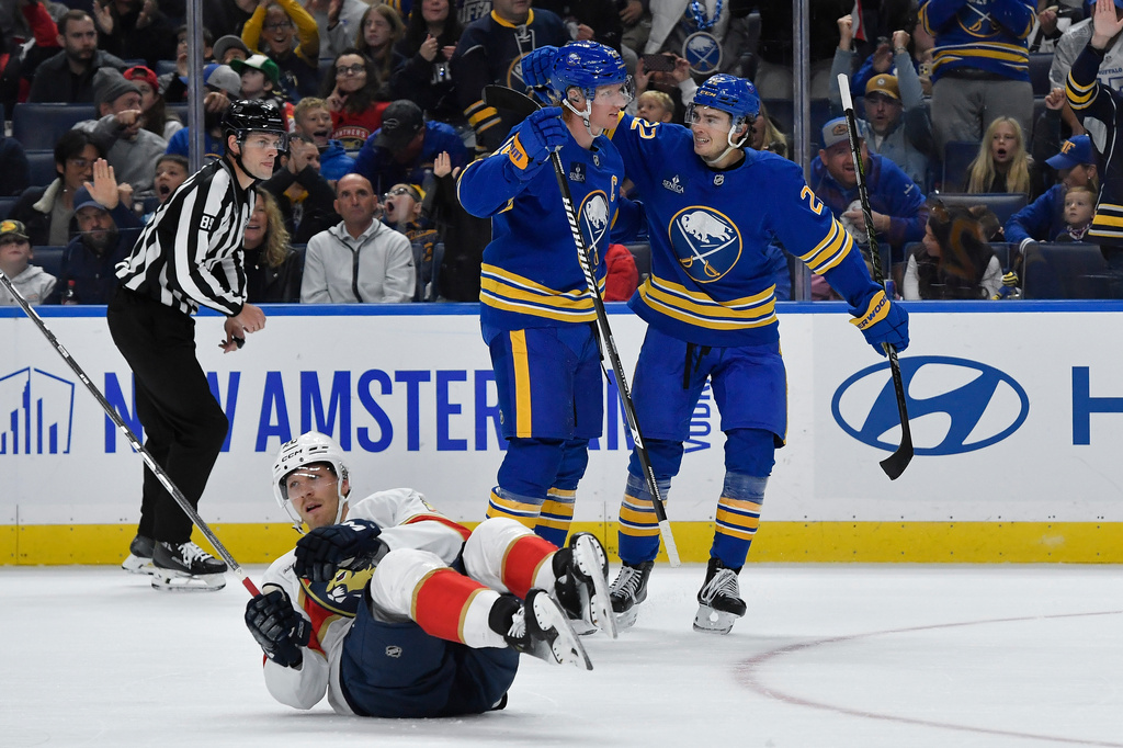 Buffalo Sabres defenseman Rasmus Dahlin, center, celebrates with right wing Jack Quinn, right, after scoring as Florida Panthers center Lars Eller (20) lays on the ice during the first period of an NHL hockey game Monday, Oct. 12, 2026, in Buffalo, N.Y. (AP Photo/Adrian Kraus)