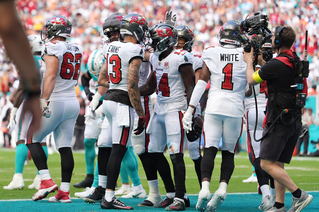 Tampa Bay Buccaneers wide receiver Chris Godwin Jr. (14) celebrates with wide receiver Mike Evans (13) after scoring a touchdown against the Miami Dolphins during the first half of an NFL football game Sunday, Dec. 28, 2025, in Miami Gardens, Fla. (AP Photo/Rebecca Blackwell)
