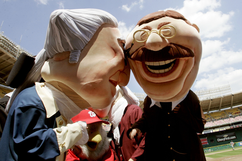 FILE - Howard Fendrich, Associated Press Washington sports writer, right, dressed as President Teddy Roosevelt, and Mark Zuckerman, Washington Times sports writer dressed as President George Washington, bump heads as they celebrate after competing in the fan favorite 'Presidents-Race' which is held in the middle of the fourth inning during Washington Nationals baseball games, Thursday, Aug. 17, 2006 at RFK Stadium in Washington. (AP Photo/Pablo Martinez Monsivais, File)