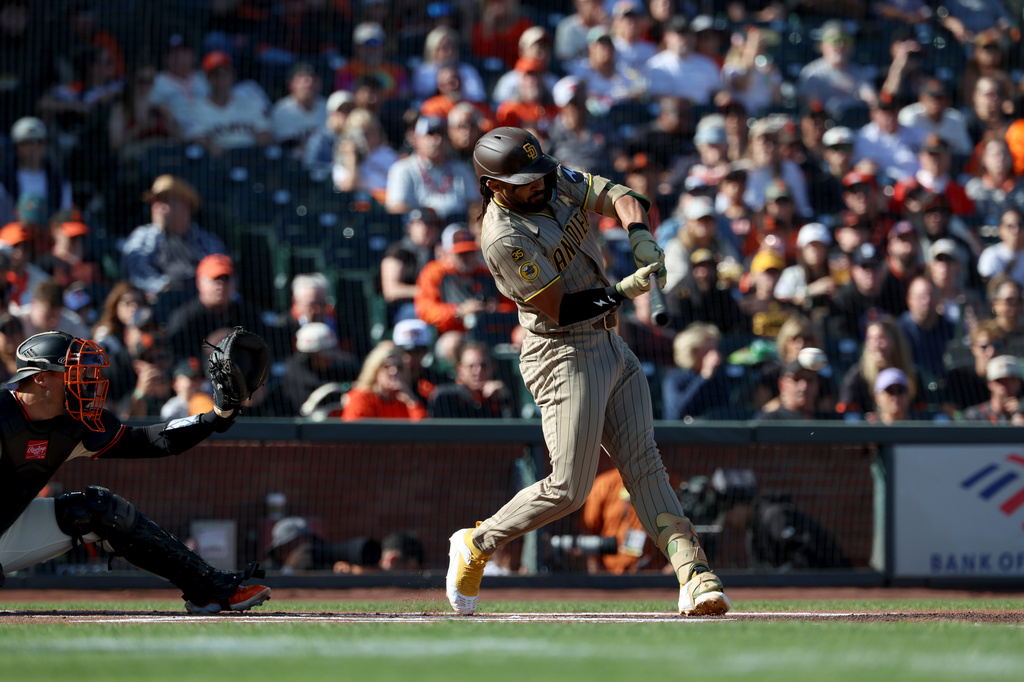 San Diego Padres' Fernando Tatis Jr., right, hits a single in front of San Francisco Giants catcher Andrew Knizner, left, during the first inning of a baseball game in San Francisco, Sunday, Sept. 13, 2026. (AP Photo/Jed Jacobsohn)