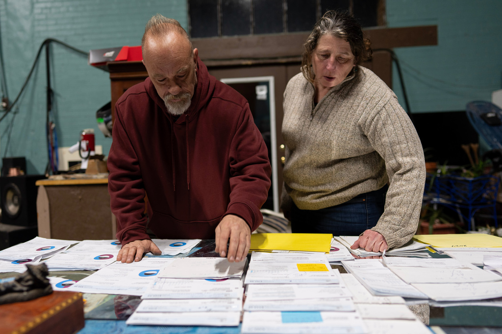 Lock 24 RV Park and Campground manager Eric Pinson, left, and Kirsten Haas pore over the campground's electric bills, at their home at the campground in Racine, Ohio, Friday, March 13, 2026. (AP Photo/Carolyn Kaster)