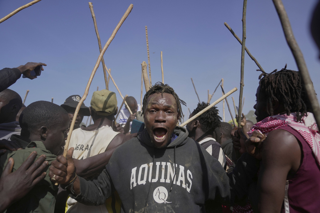 A spectator dances and sings after bull Shakahola won bullfighting match, in Kakamega, Kenya, Saturday, Nov. 29, 2025. (AP Photo/Brian Inganga)