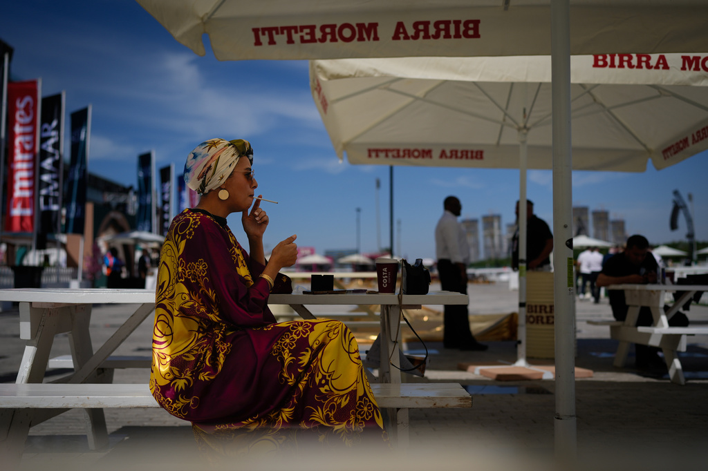 A racegoer smokes a cigarette at Meydan Racecourse ahead of the Dubai World Cup, United Arab Emirates, Saturday, March 28, 2026. (AP Photo/Altaf Qadri)