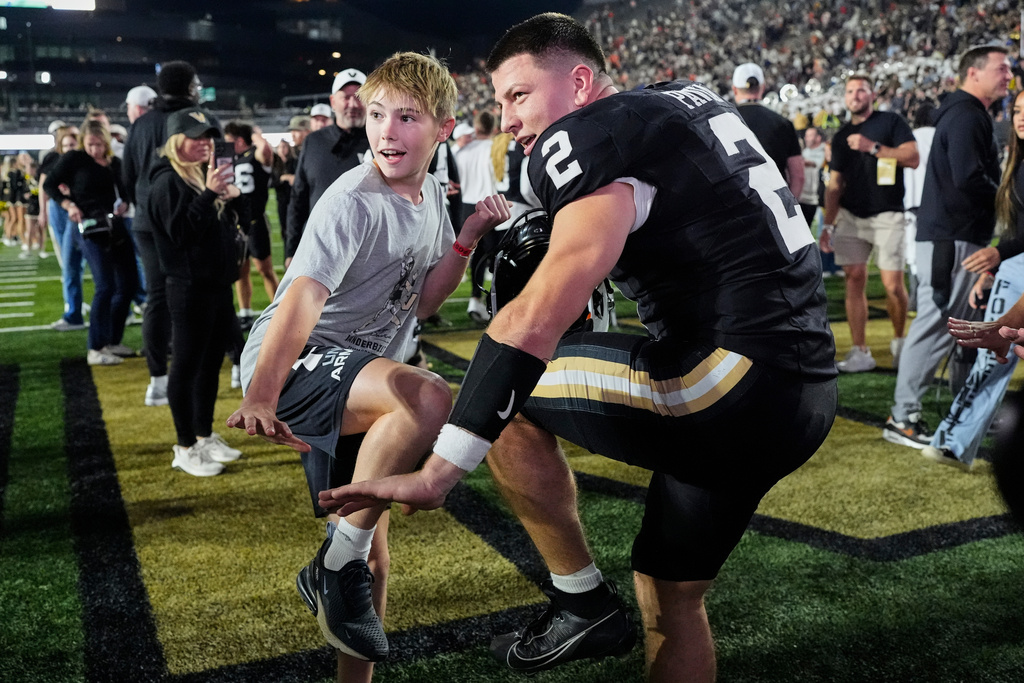 Vanderbilt quarterback Diego Pavia (2) and Xavier Swallows, left, make the Heisman pose after the team's win an NCAA college football game against Auburn, Saturday, Nov. 8, 2025, in Nashville, Tenn. (AP Photo/George Walker IV)