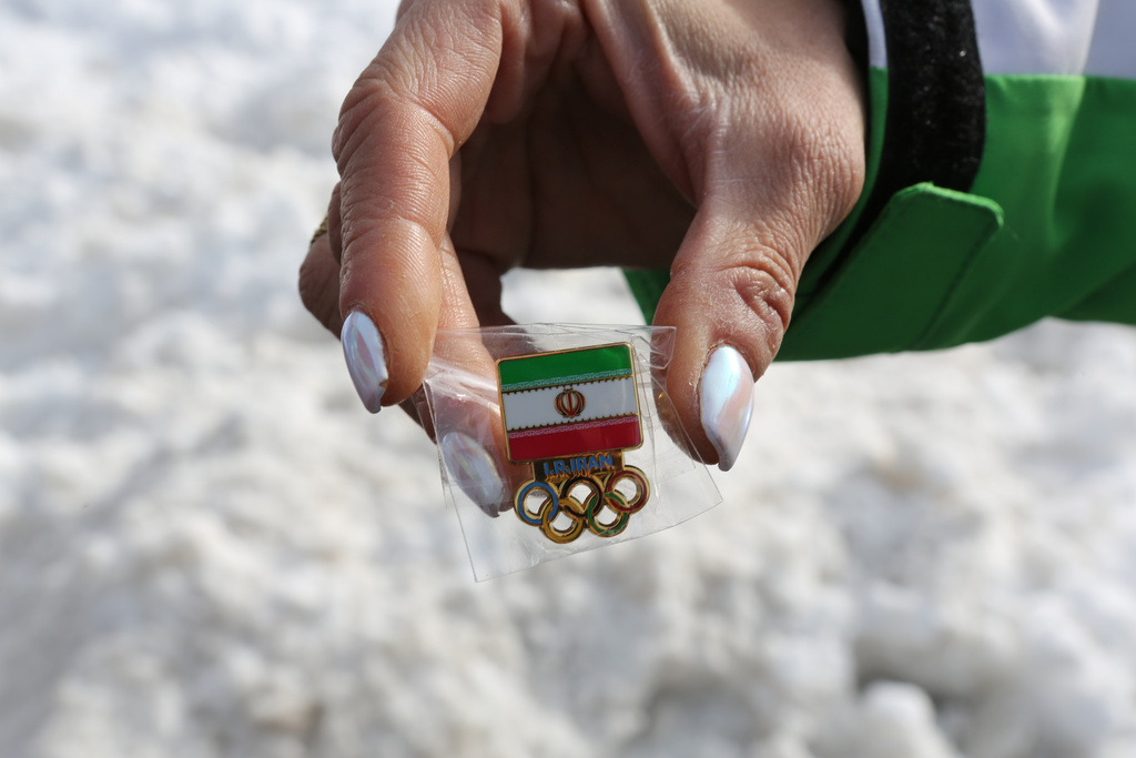 Iran's coach for Alpine women's skiing, Mitra Kalhor displays Iran's national pin for the 2026 Winter Olympics at the Cortina Olympic Village, in Cortina d'Ampezzo, Italy, Thursday Feb. 5, 2026. (AP Photo/Jennifer McDermott)