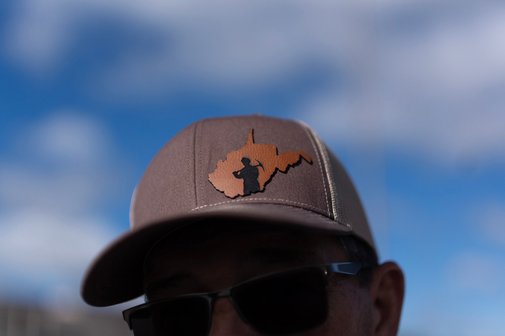 Arvin Hanshaw, of Summersville, W.Va., wears a hat with a miner silhouetted by the state of West Virginia, as he joins a group going to Washington, D.C., to protest the government's delay of the silica rule passed last year to limit exposure to deadly silica in coal mines, on Oct. 13, 2025, in Mount Hope, W.Va. (AP Photo/Carolyn Kaster)
