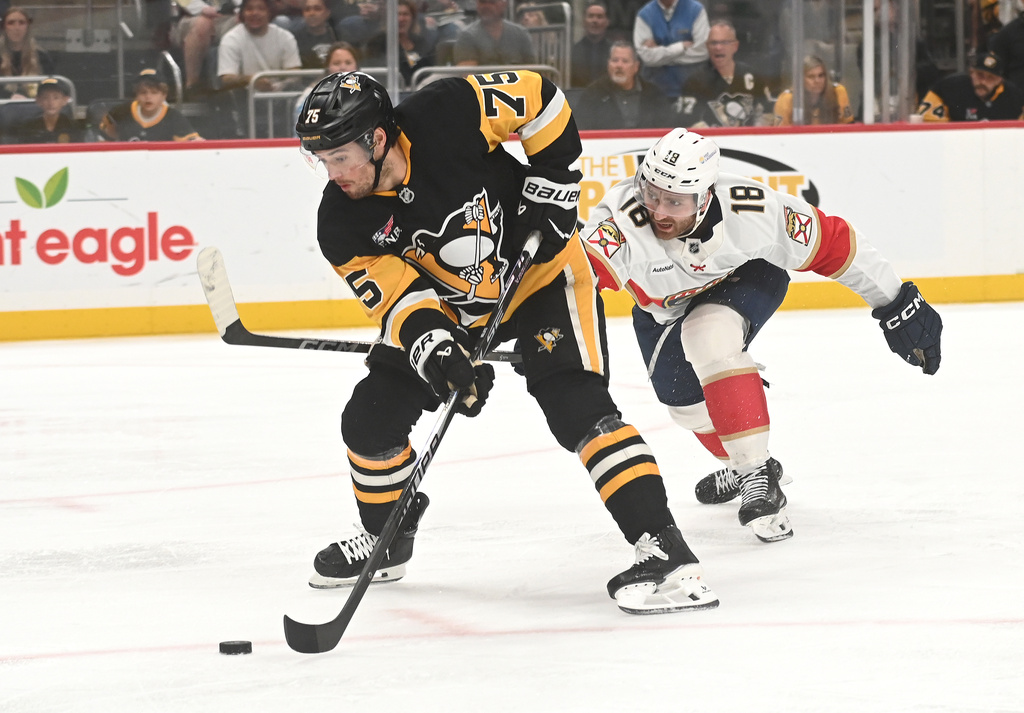 Pittsburgh Penguins defenseman Connor Clifton (75) moves the puck under pressure from Florida Panthers left wing Noah Gregor (18) during the second period of an NHL game, Saturday, April 4, 2026, in Pittsburgh. (AP Photo/Philip G. Pavely)