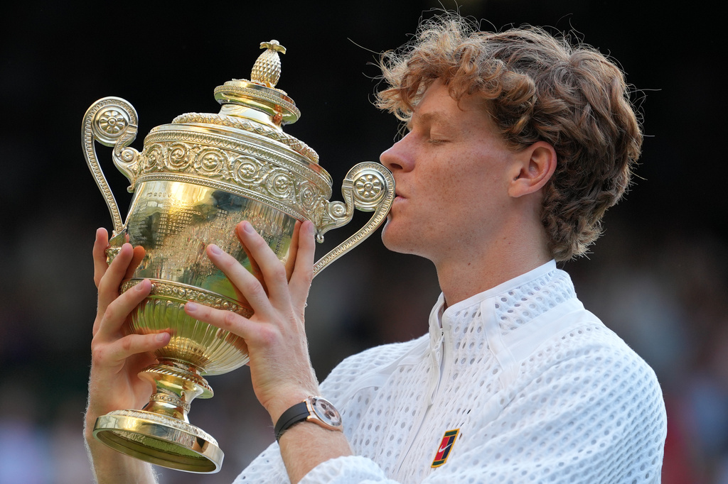 Jannik Sinner of Italy kisses the winners trophy after defeating Alexander Zverev of Germany in the men's singles final at Wimbledon Tennis Championships in London, Sunday, July 12, 2026. (AP Photo/Kin Cheung)