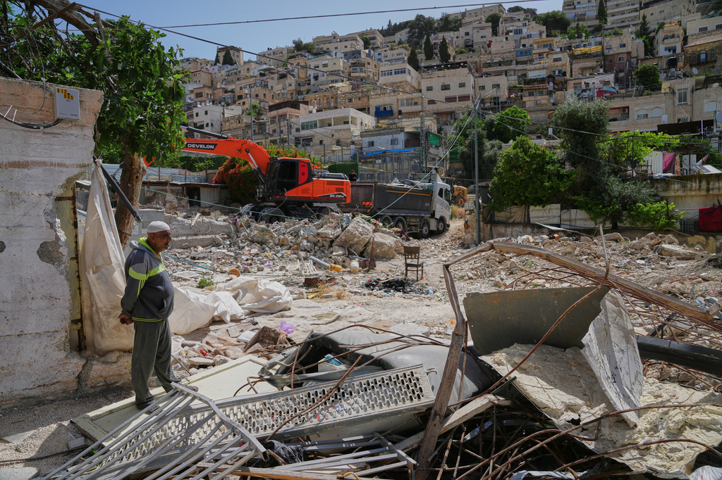 A Palestinian man looks on as an excavator clears the rubble of homes demolished by Israeli authorities in the Silwan neighborhood of east Jerusalem, May 19, 2026. (AP Photo/Mahmoud Illean)