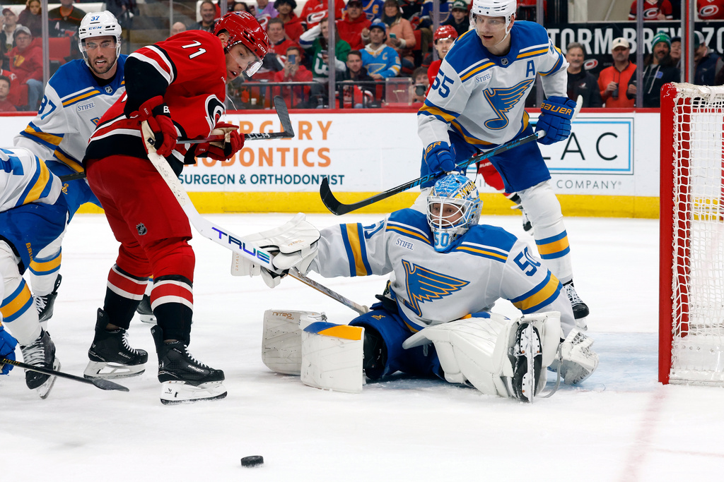 Carolina Hurricanes' Taylor Hall (71) watches the puck with St. Louis Blues goaltender Jordan Binnington (50) and Colton Parayko (55) looking on during the second period of an NHL hockey game in Raleigh, N.C., Thursday, March 12, 2026. (AP Photo/Karl DeBlaker)