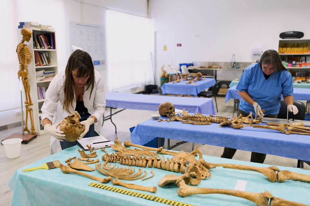 Forensic anthropologist Mariella Fumagalli, left, and Gabriela Ghidini, examine the bones of murdered and missing persons from the military dictatorship era, in the lab of the Argentine Forensic Anthropology Team in Buenos Aires, Argentina, Tuesday, March 3, 2026. (AP Photo/Rodrigo Abd)