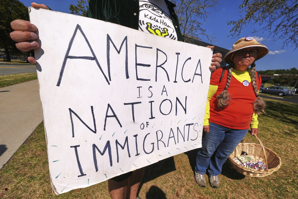 Protesters picket outside the U.S. Immigration and Customs Enforcement regional field office, Thursday, Sept. 11, 2025, in Burlington, Mass. (AP Photo/Charles Krupa)