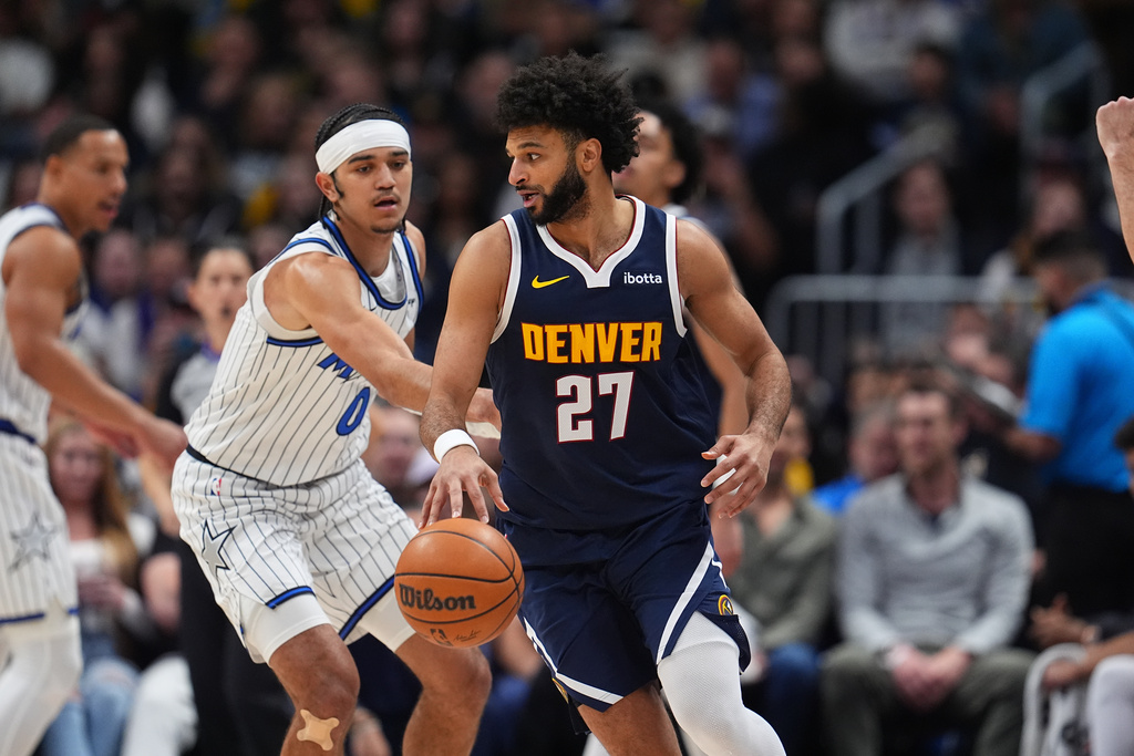 Denver Nuggets guard Jamal Murray, front, drives to the basket as Orlando Magic guard Anthony Black defends in the first half of an NBA basketball game, Thursday, Dec. 18, 2025, in Denver. (AP Photo/David Zalubowski)
